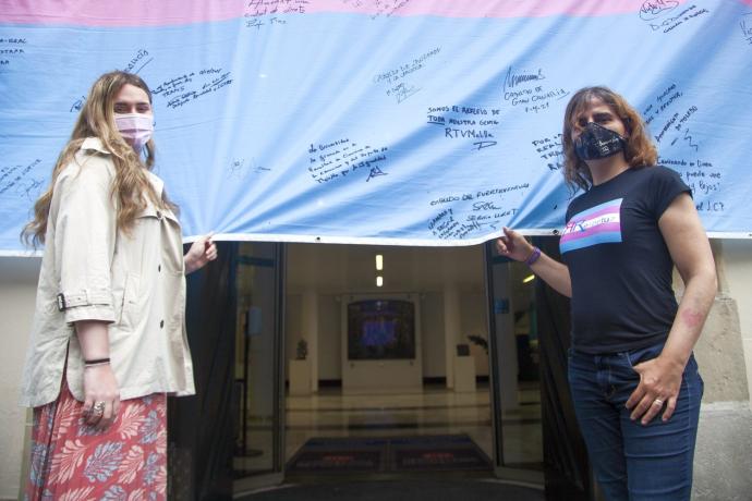 Mei Arregi y Sarai Montes con la bandera trans, firmada por las autoridades, en Gasteiz.