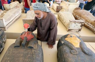 Un trabajador del grupo de investigación limpia uno de los sarcófagos encontrados en la necrópolis de Saqqara.