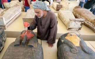 Un trabajador del grupo de investigación limpia uno de los sarcófagos encontrados en la necrópolis de Saqqara.