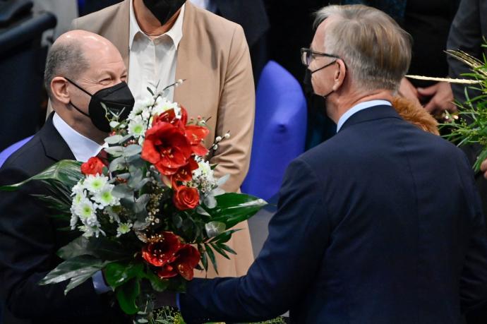 Olaf Scholz (i) recibe un ramo de flores tras su elección como canciller.