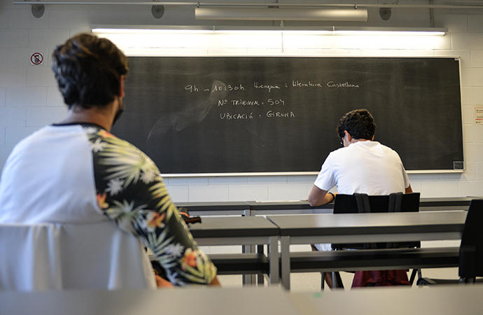 Dos estudiantes esperan antes de realizar un examen de selectividad en Girona.