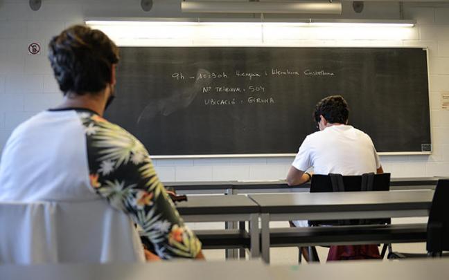 Dos estudiantes esperan antes de realizar un examen de selectividad en Girona. Dos estudiantes esperan antes de realizar un examen de selectividad en Girona.