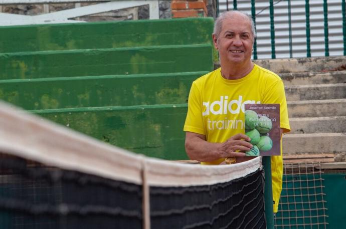 Josemari Sexmilo, con un ejemplar de 'Yo fui entrenador de tenis' en la pista nº1 del Club Tenis Pamplona.