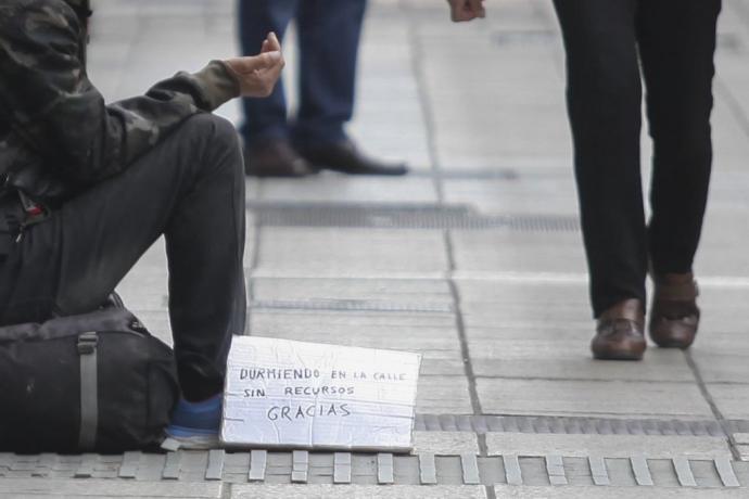 Una persona pide limosna en la calle.