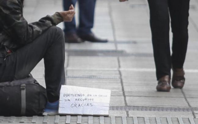 Una persona pide limosna en la calle. Una persona pide limosna en la calle.