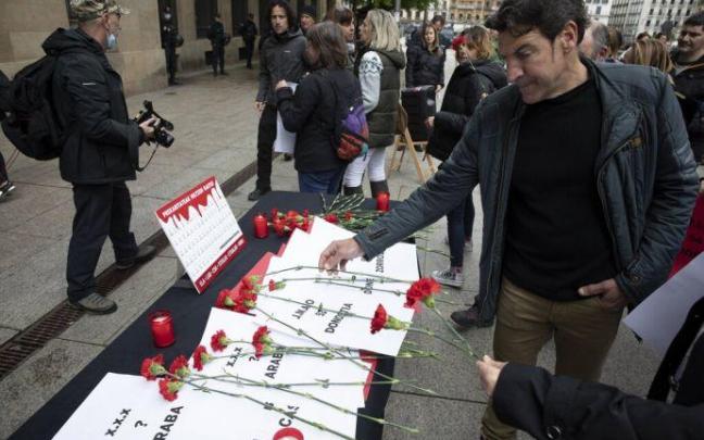 Sindicalistas colocan los claveles por los trabajadores fallecidos.