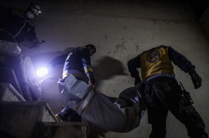 Dos hombres trasladan el cadáver de un niño muerto durante el ataque militar norteamericano.