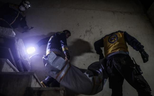 Dos hombres trasladan el cadáver de un niño muerto durante el ataque militar norteamericano.