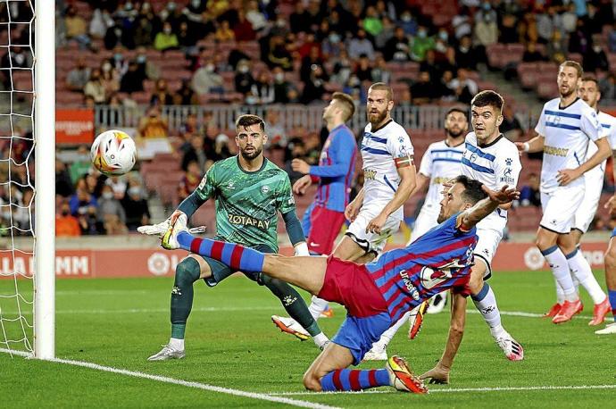 Busquets se estira para centrar un balón ante la atenta mirada de Sivera, Martín y Laguardia, en el choque disputado en el Nou Camp. Foto: Efe