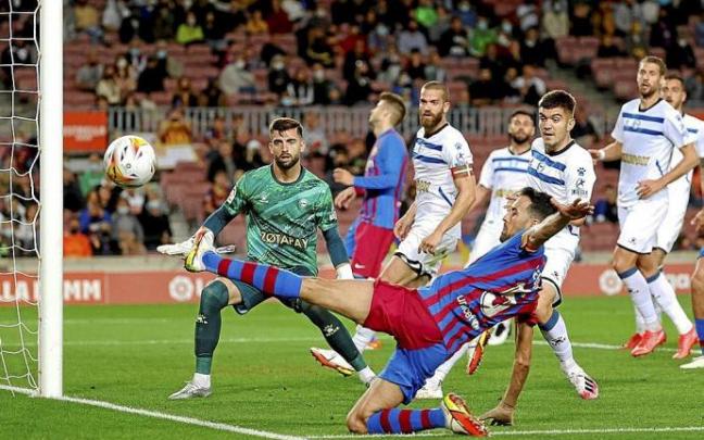 Busquets se estira para centrar un balón ante la atenta mirada de Sivera, Martín y Laguardia, en el choque disputado en el Nou Camp. Foto: Efe