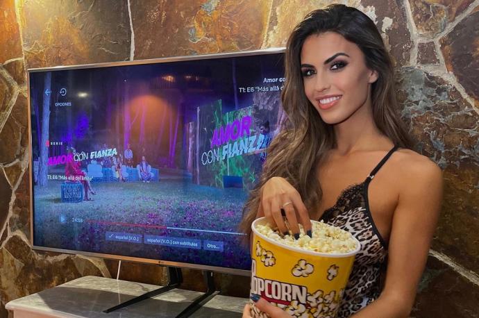 Sofía Suescun, posando delante de una televisión que emite 'Amor con fianza'.