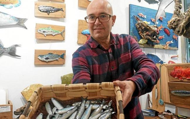 Mikel Aranburu muestra su cesta de sardinas, brillantes, como recién pescadas.