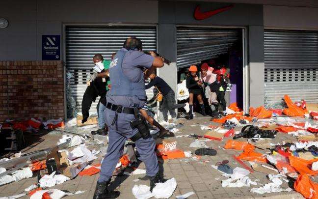 Un agente de policía apunta con su arma a los asaltantes de un comercio en la ciudad de Durban Un agente de policía apunta con su arma a los asaltantes de un comercio en la ciudad de Durban