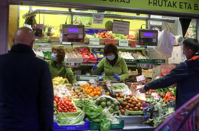 Varias personas realizan la compra en un supermercado.