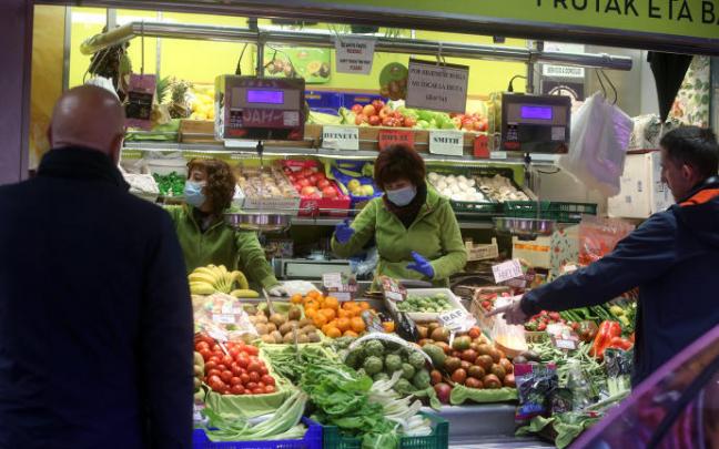 Varias personas realizan la compra en un supermercado.