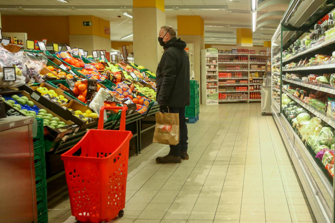 Un hombre en la sección de frutería de un supermercado.
