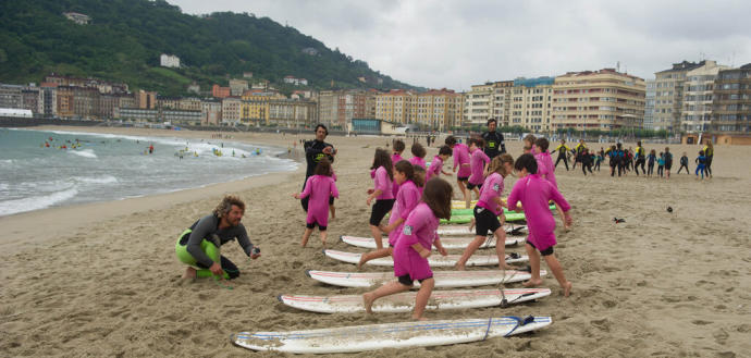 Niños y niñas se preparan para hacer surf en la playa de la Zurriola