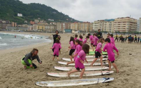 Niños y niñas se preparan para hacer surf en la playa de la Zurriola
