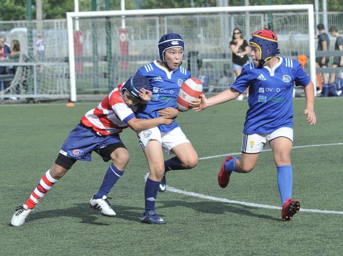 Varios niños juegan a rugby.