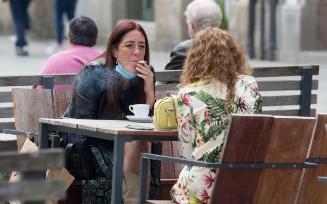 Dos mujeres fuman en una terraza Dos mujeres fuman en una terraza