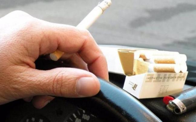 Un hombre fuma en el coche. Un hombre fuma en el coche.