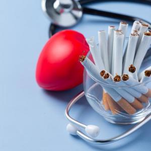 Un vaso con cigarrillos, un estetoscopio y un corazón de espuma.