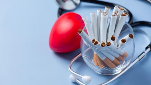 Un vaso con cigarrillos, un estetoscopio y un corazón de espuma.