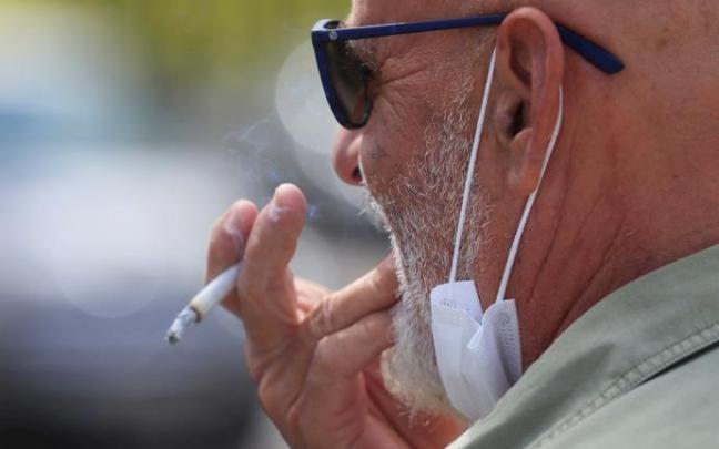 Un hombre fuma un cigarrillo Un hombre fuma un cigarrillo