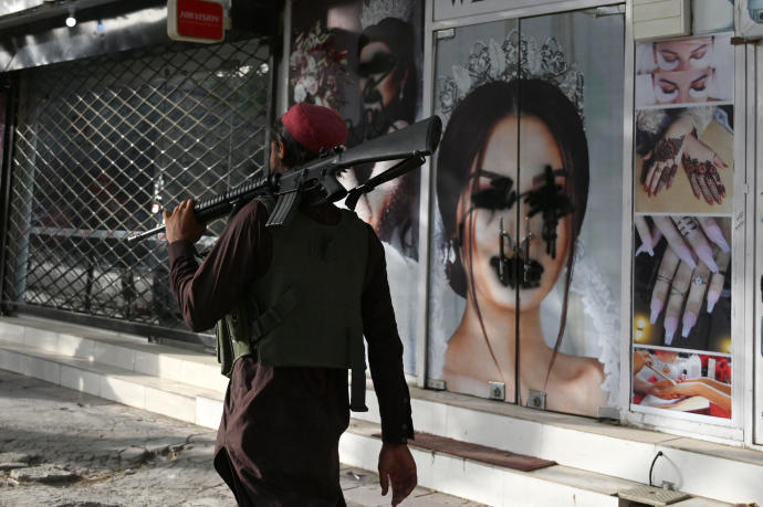 Un talibán pasa junto a un centro de belleza en Kabul.