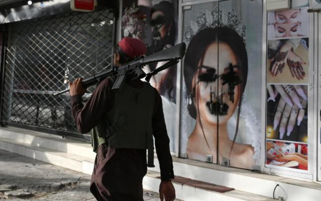 Un talibán pasa junto a un centro de belleza en Kabul.