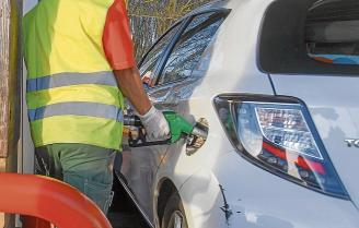 Un hombre echa gasolina a su coche.