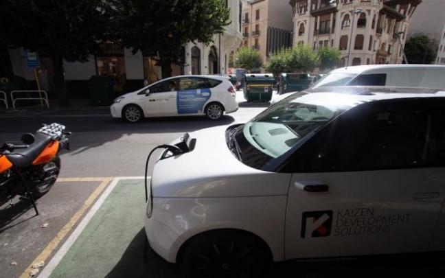 Un taxi circula por San Ignacio junto a un punto de recarga eléctrica.