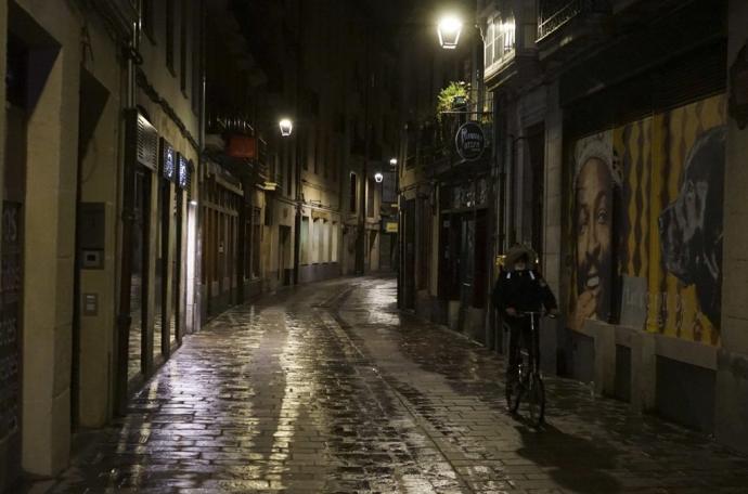 Un ciudadano sobre una bicicleta durante una noche en el Casco Viejo de Vitoria.