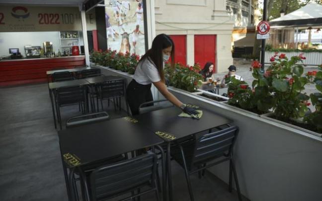 Una camarera limpia las mesas de una terraza instalada junto a la Plaza de Toros. Una camarera limpia las mesas de una terraza instalada junto a la Plaza de Toros.