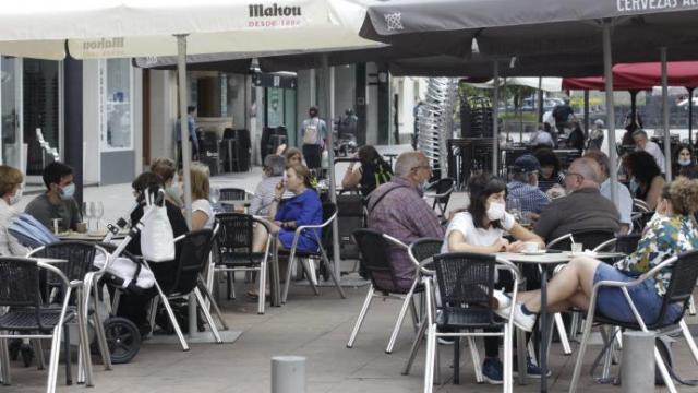 Personas sentadas en la terraza de un bar.