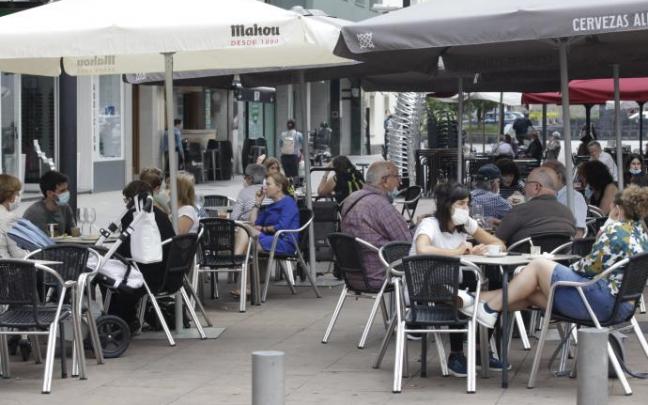 Personas sentadas en la terraza de un bar.