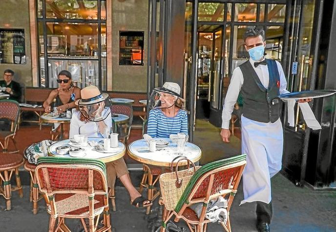 Clientes en la terraza de una cafetería en Francia.