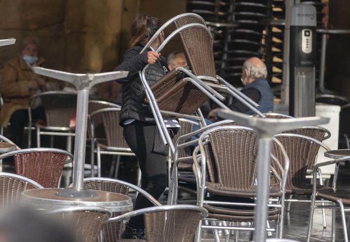 Una trabajadora desmonta una terraza durante la pandemia