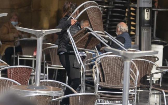 Una trabajadora desmonta una terraza durante la pandemia Una trabajadora desmonta una terraza durante la pandemia