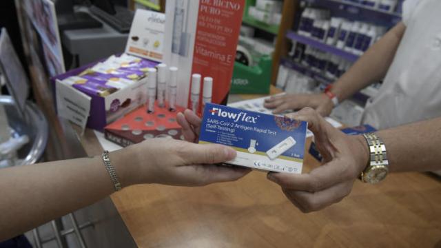 Un farmacéutica muestra un test de antígenos.