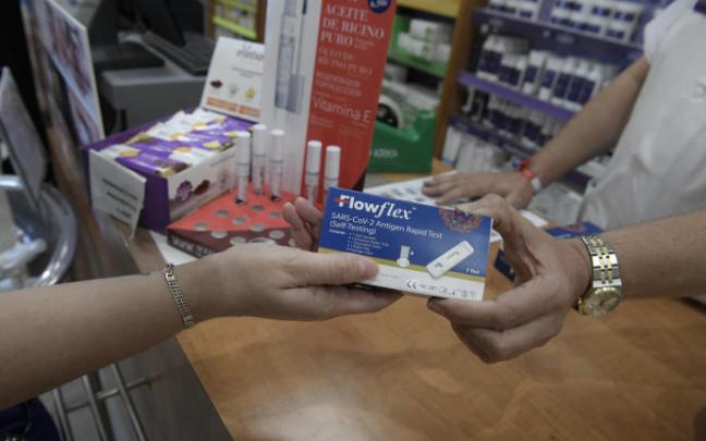 Un farmacéutica muestra un test de antígenos. Un farmacéutica muestra un test de antígenos.