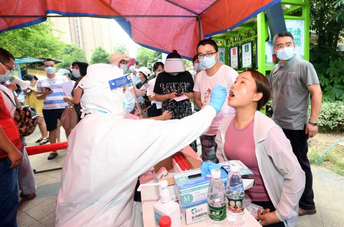 Un sanitario realiza una prueba a una mujer en China.