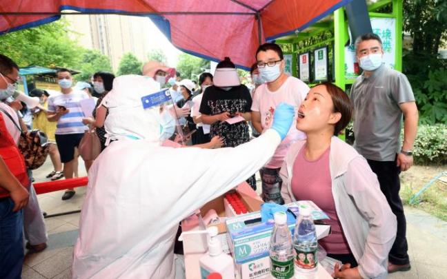 Un sanitario realiza una prueba a una mujer en China. Un sanitario realiza una prueba a una mujer en China.