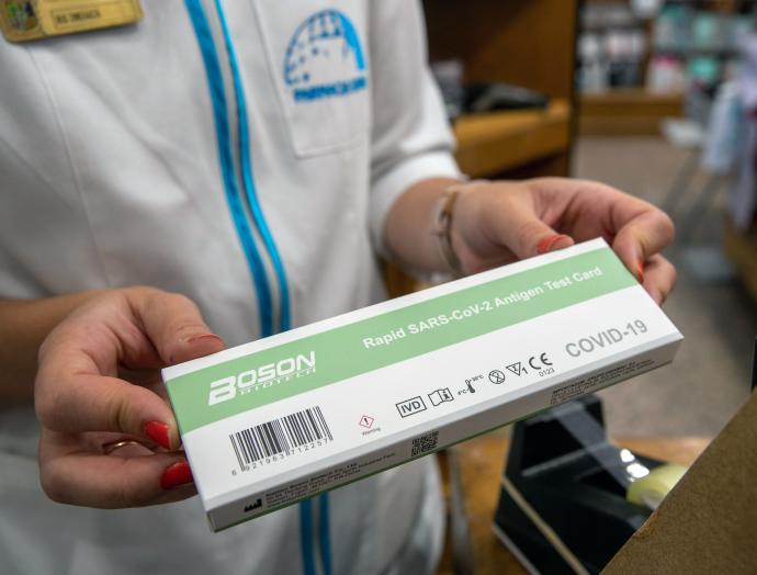 Un farmacéutico sostiene un test de antígenos.