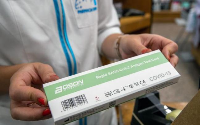 Un farmacéutico sostiene un test de antígenos.