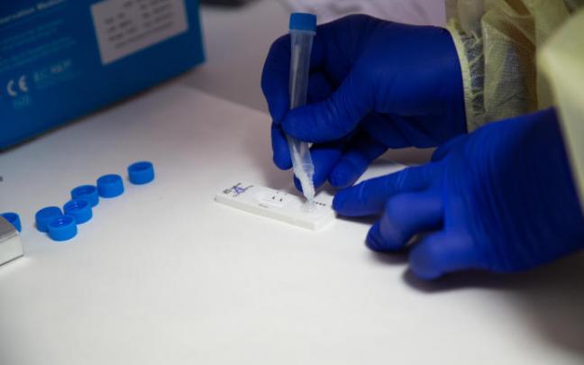 Una sanitaria comprueba el resultado de un test de antígenos a uno de los jóvenes participantes en las celebraciones de Mallorca