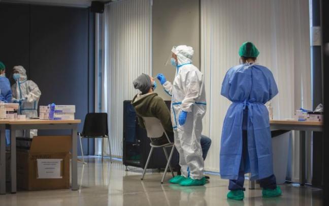 Un hombre recibe una prueba PCR en un dispositivo de cribados masivos.