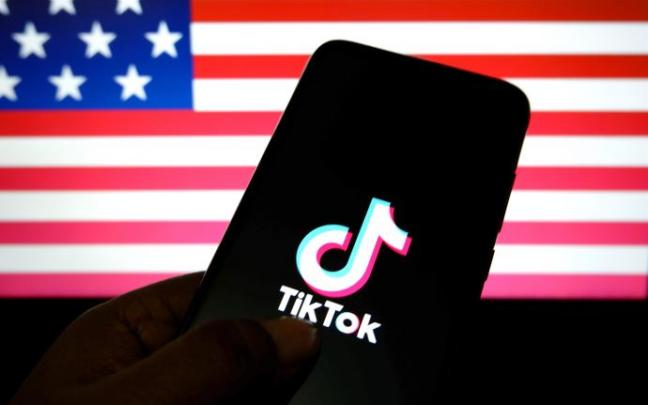 Logotipo de TikTok sobre un fondo con la bandera de Estados Unidos. Logotipo de TikTok sobre un fondo con la bandera de Estados Unidos.