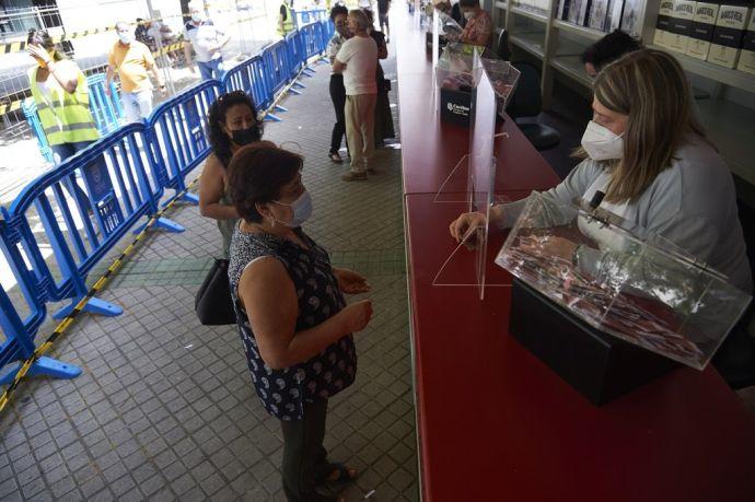 Una clienta compra un boleto en la Tómbola de Cáritas