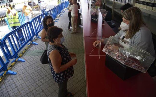 Una clienta compra un boleto en la Tómbola de Cáritas